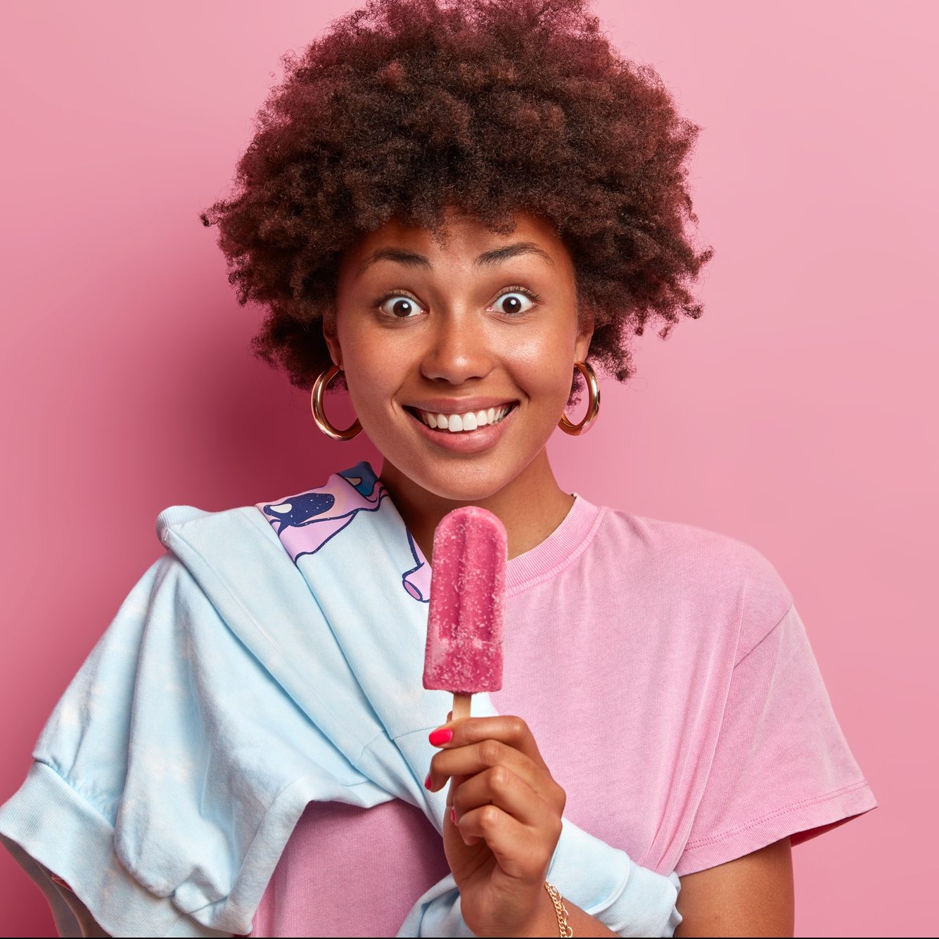 photo-of-happy-surprised-dark-skinned-woman-with-afro-hair-holds-delicious-popsicle-and-dressed-casu-e1622718569709.jpg